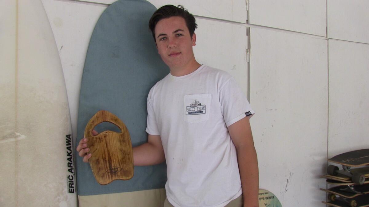 Notre Dame's Luke McGarry shows off his customized handplane made in his garage for surfing charity.