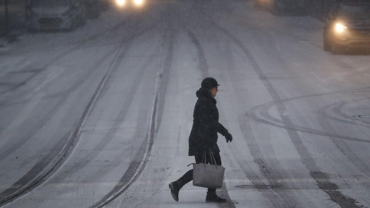 A commuter braves the wind and snow in frigid weather Wednesday in Cincinnati.