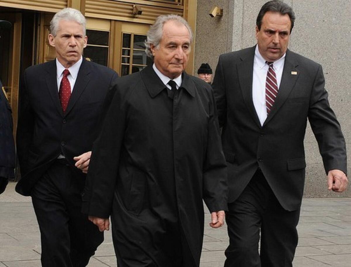 Bernard Madoff, center, leaves a New York federal courthouse.