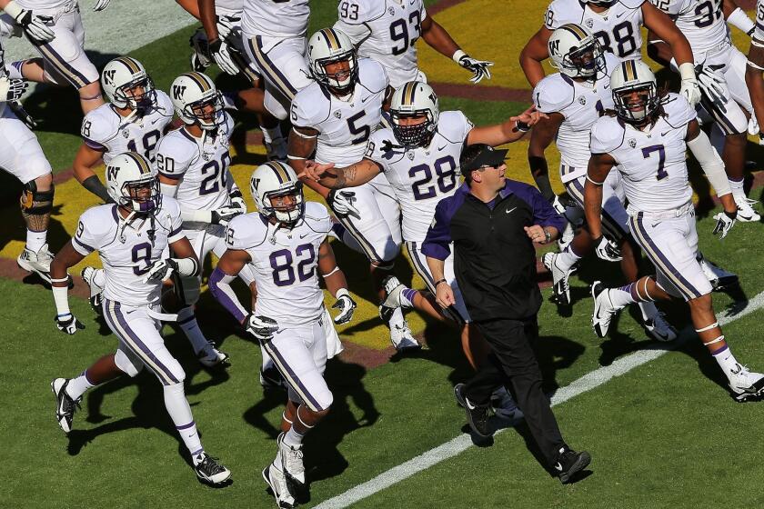 Steve Sarkisian, USC's newly named football coach, met with Trojans players Monday night. Above, he is shown leading the Washington Huskies onto the field in October to face Arizona State.