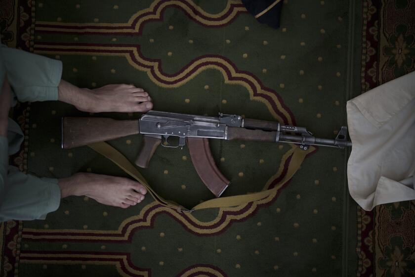 A Taliban fighter lays his AK-47 rifle down during Friday prayers at a Mosque in Kabul, Afghanistan, Friday, Sept. 10, 2021. (AP Photo/Felipe Dana)