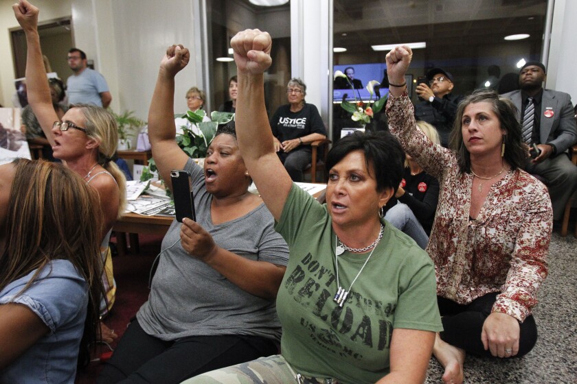 Tasha Williamson and protesters chant while watching video of a National City council meeting