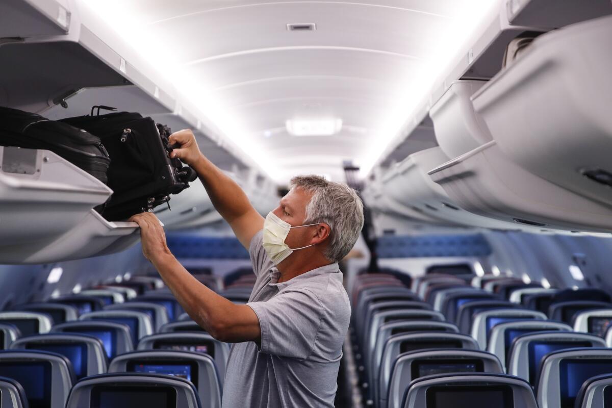 A passenger wears a mask aboard a Delta Air Lines flight. 
