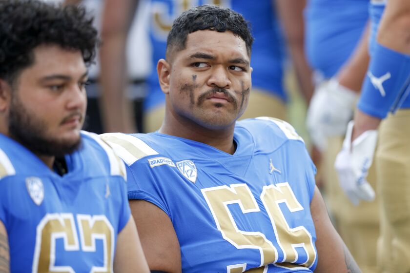 UCLA Bruins offensive lineman Atonio Mafi (56) looks at his coach from the bench during a college football game