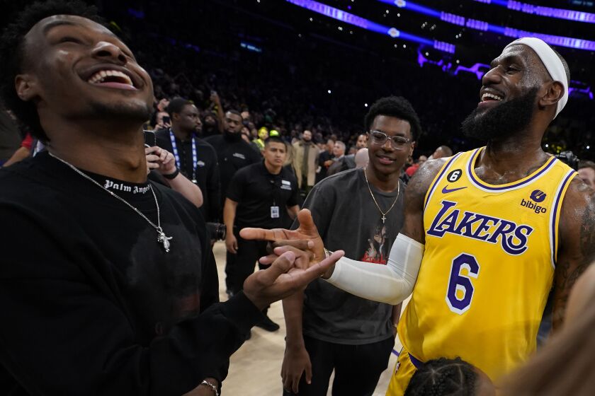 Lakers forward LeBron James, right, celebrates with his sons Bronny, left, and Bryce 