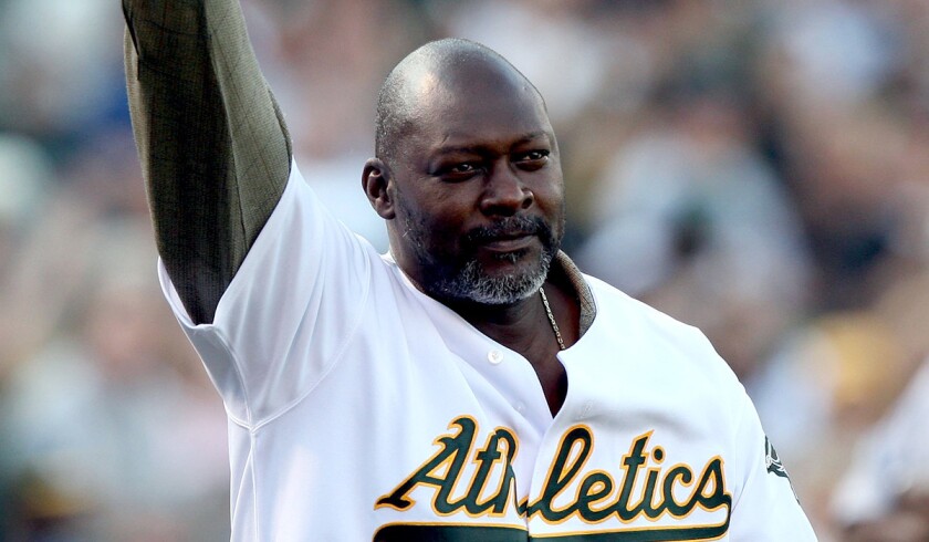 Dave Stewart waves to fans during a ceremony to honor the 1989 World Series team before the Oakland A's hosted the San Francisco Giants.