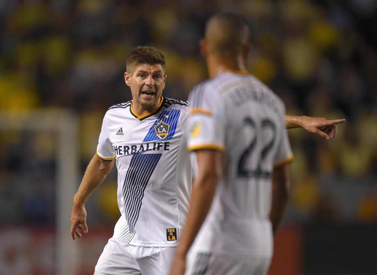 Galaxy midfielder Steven Gerrard talks to defender Leonardo during the first half of a match against Club America.