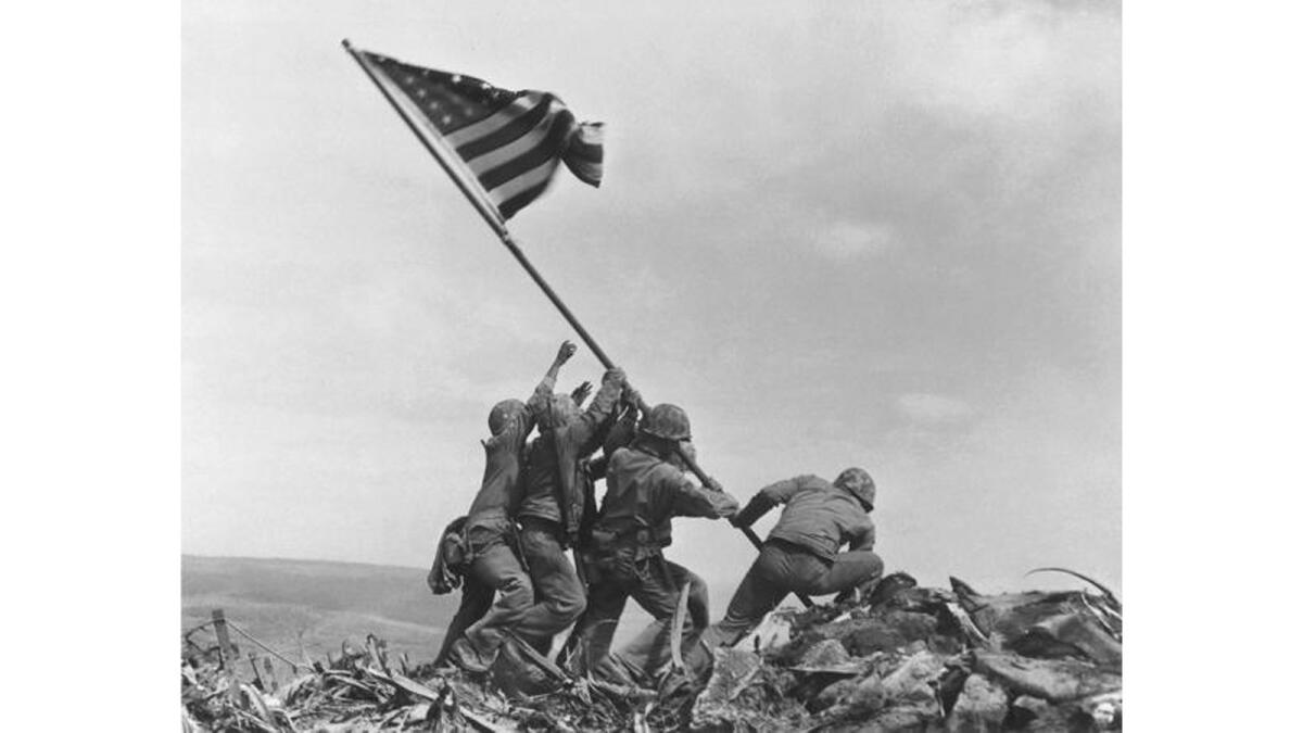 U.S. Marines of the 28th Regiment of the Fifth Division raise the American flag atop Mt. Suribachi, Iwo Jima on Feb. 23, 1945.