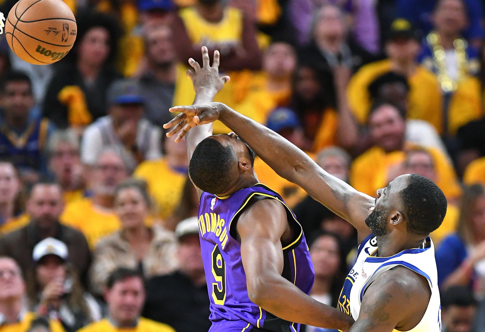 Lakers forward Tristan Thompson, left, gets hit in the face by Warriors forward Draymond Green.