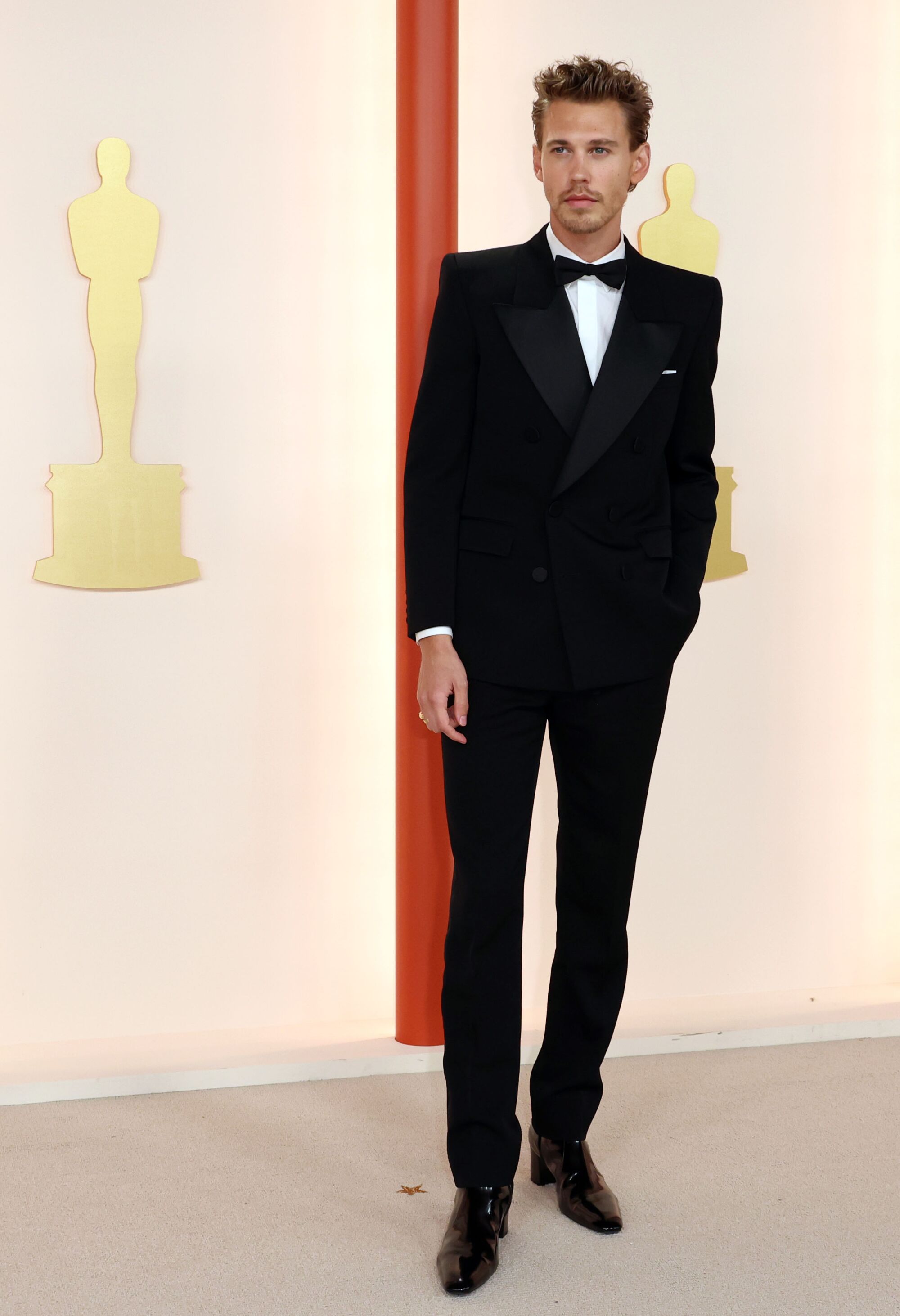 Austin Butler in a black tuxedo with peg-legged pants.