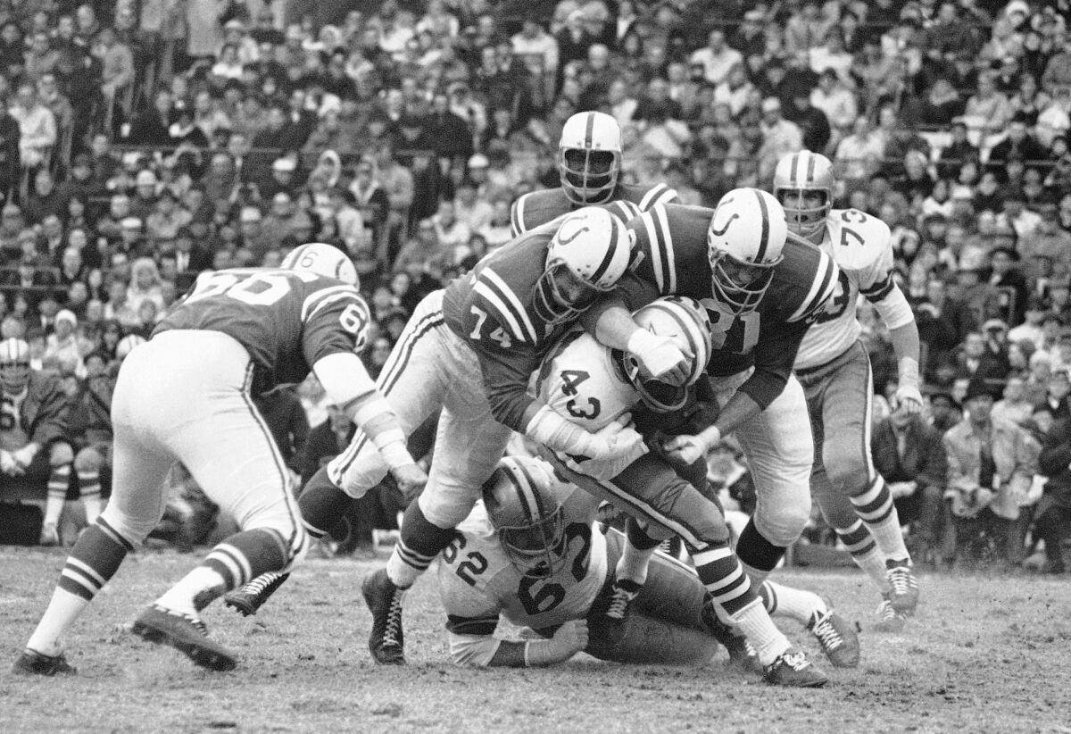 FILE - Dallas Cowboys' Don Perkins is taken down by Baltimore Colts' Billy Ray Smith (74) and Ordell Braase (81) during a football game in Baltimore on Dec. 3, 1967. Perkins, a six-time Pro Bowl running back with the Cowboys in the 1960s, has died. He was 84. The NFL team and the University of New Mexico, where Perkins was a standout player before his professional career, said Perkins died Thursday, June 9, 2022. No cause of death was revealed. (AP Photo, File)