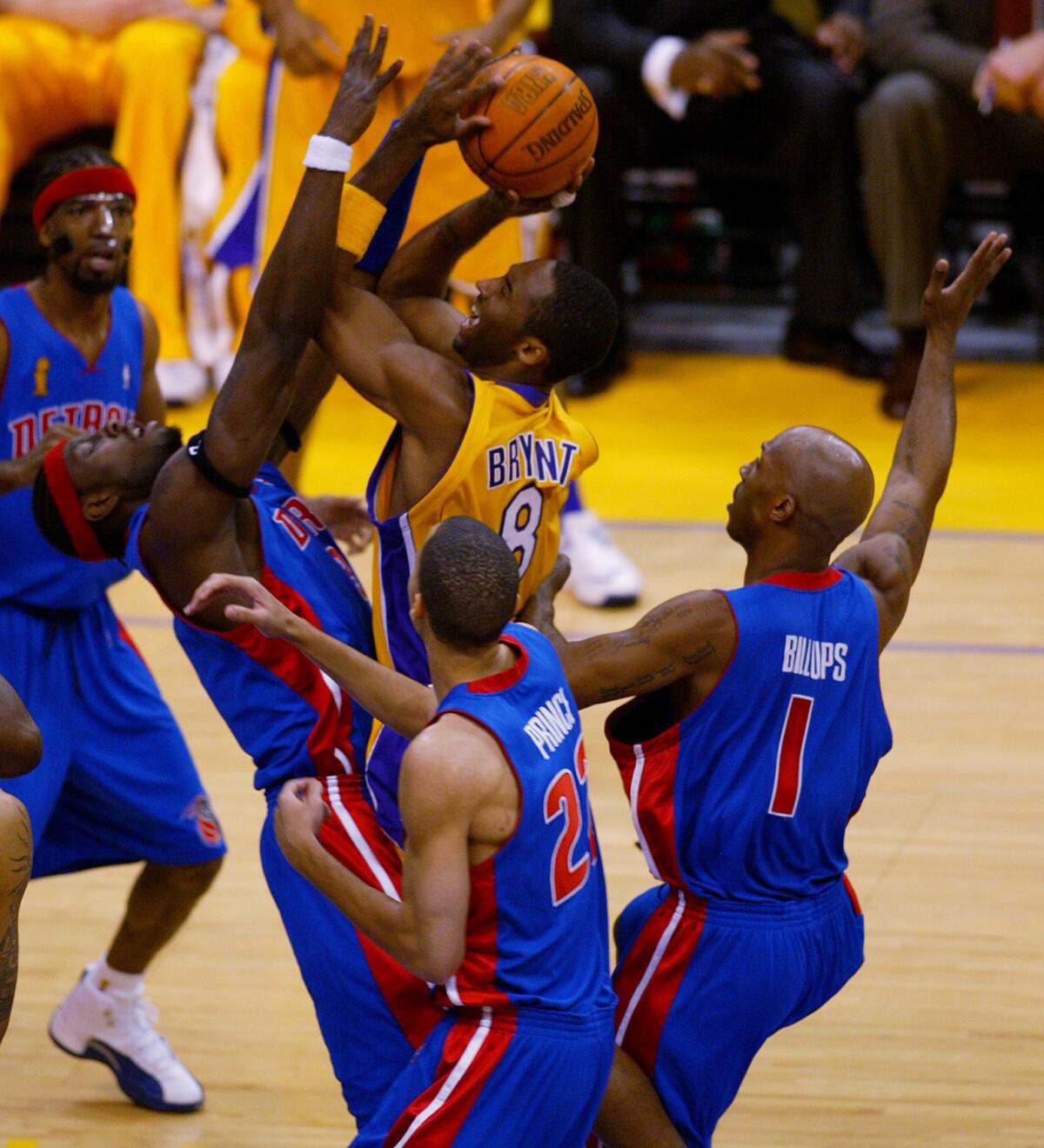 Kobe forces a shot against the tough defense of Detroit Pistons. (Los Angeles Times)