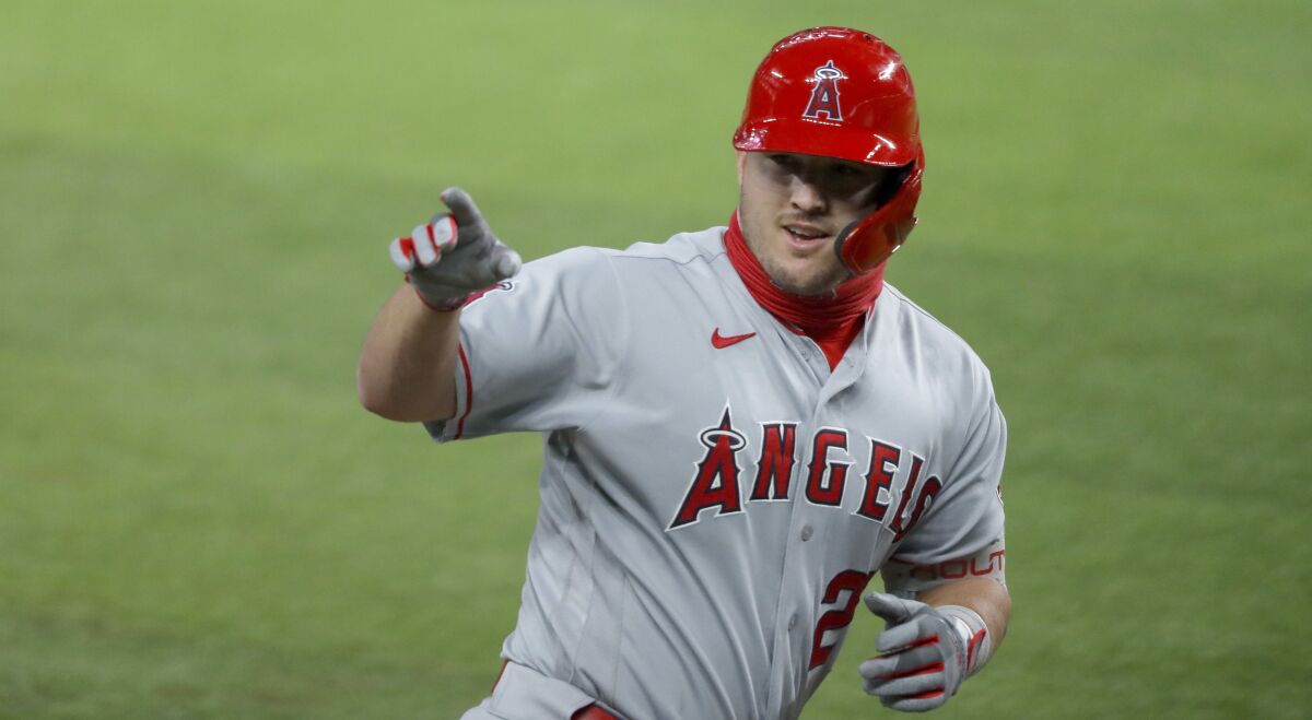 The Angels' Mike Trout points to the dugout after hitting a two-run homer against the Texas Rangers on Aug. 7, 2020.