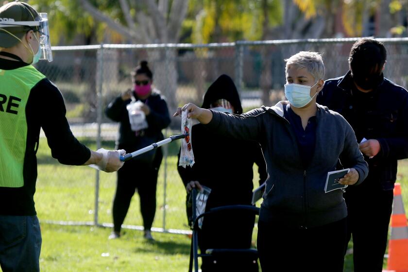 BALDWIN PARK CALIF. - DEC.21, 2020. People submit self-administered COVID-19 tests at a regional pop-up walk-up testing site in Baldwin Park on Monday, Dec. 21, 2020. (Luis Sinco/Los Angeles Times)