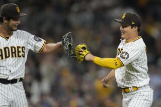 San Diego Padres second baseman Ha-Seong Kim, right, touches gloves with starting pitcher Yu Darvish after Kim threw to first for the out on Chicago Cubs' Dansby Swanson during the fourth inning of a baseball game Saturday, June 3, 2023, in San Diego. (AP Photo/Gregory Bull)