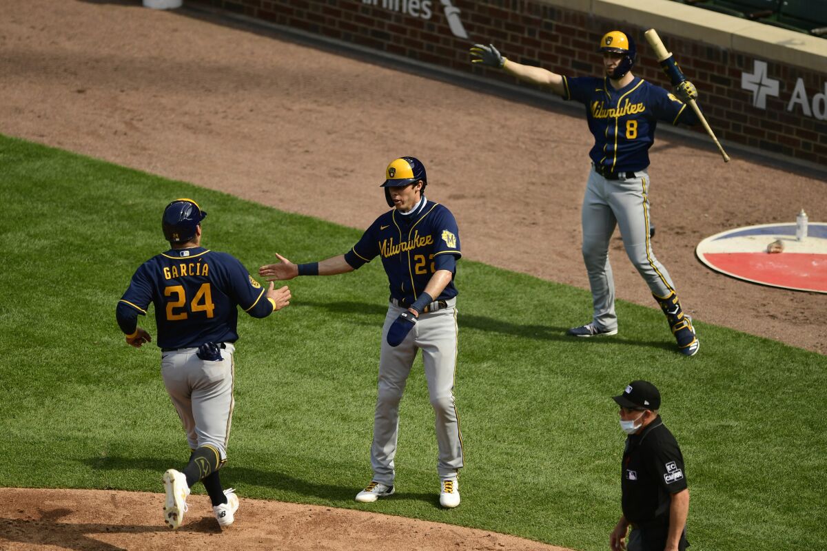 Milwaukee Brewers' Avisail Garcia (24) celebrates with teammates Christian Yelich (22) and Ryan Braun (8) after scoring on a Justin Smoak two RBI double during the fourth inning of a baseball game against the Chicago Cubs Saturday, Aug. 15, 2020, in Chicago. (AP Photo/Paul Beaty)
