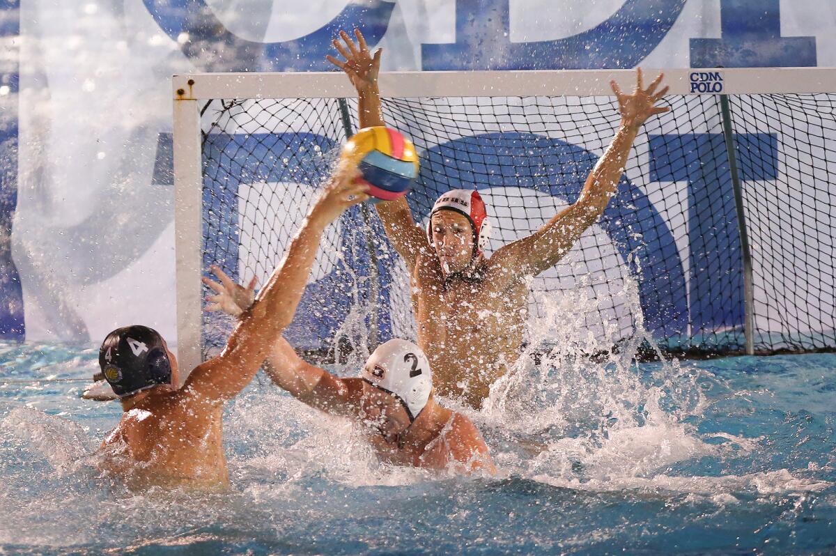 Newport Harbor's Eli Liechty (4) takes a shot over Huntington Beach's Josh Bowman (2) and scores on goalkeeper Jacob Pyle in a Surf League match on Wednesday at Corona del Mar High.