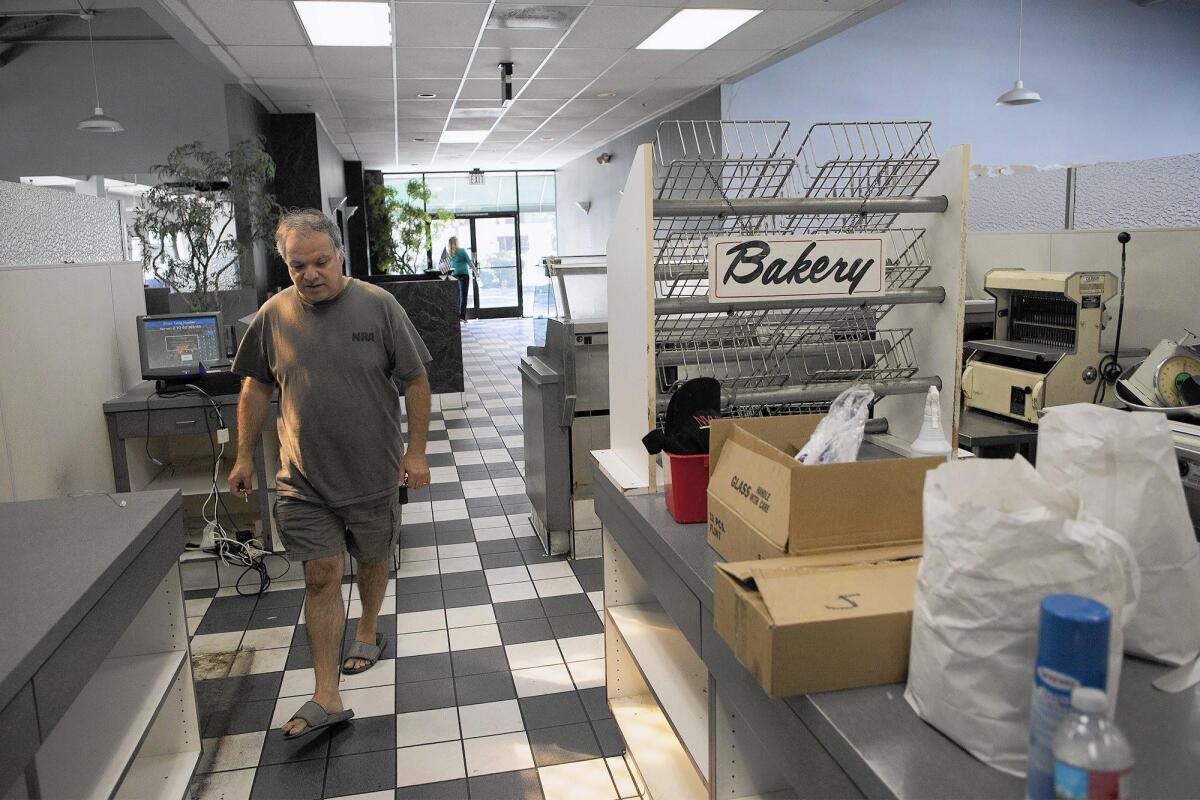 Owner Elia Challita walks through what was once the bakery as his family prepares to close Arnie's Manhattan Restaurant and Deli in Newport Beach on Friday.