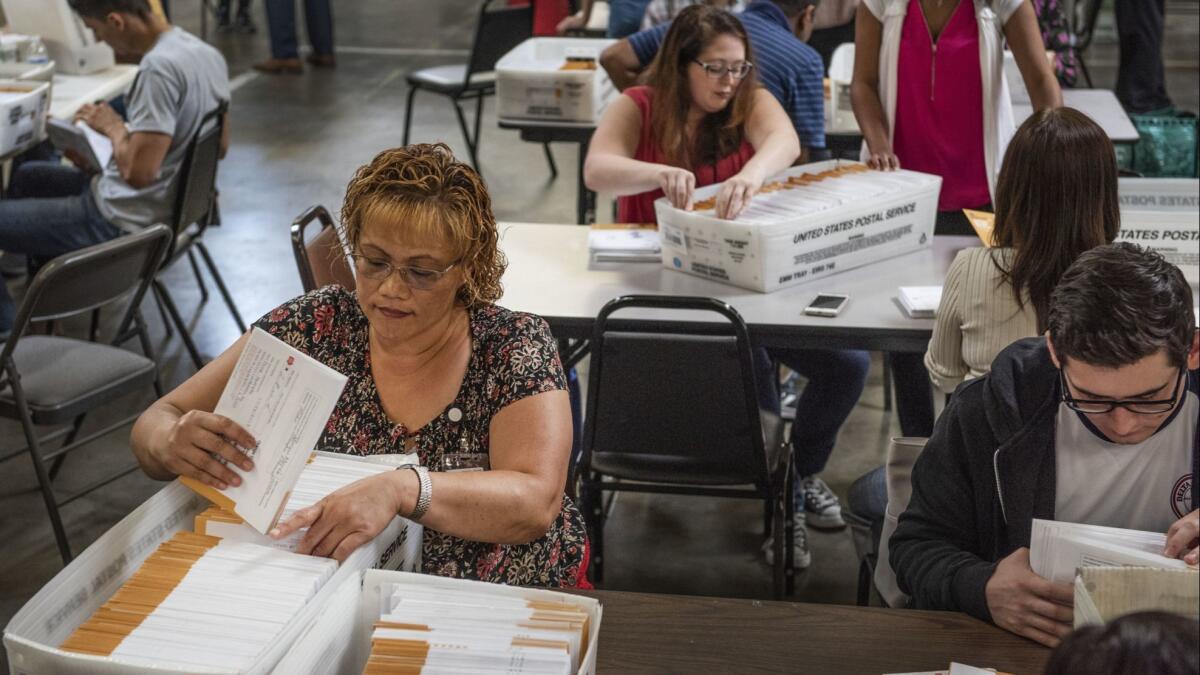 Soloi Taafua, an election aide with the Orange County Registrar of Voters, sorts through mail-in ballots on Nov. 7 in Santa Ana. Many races in Orange County remain too close to call.