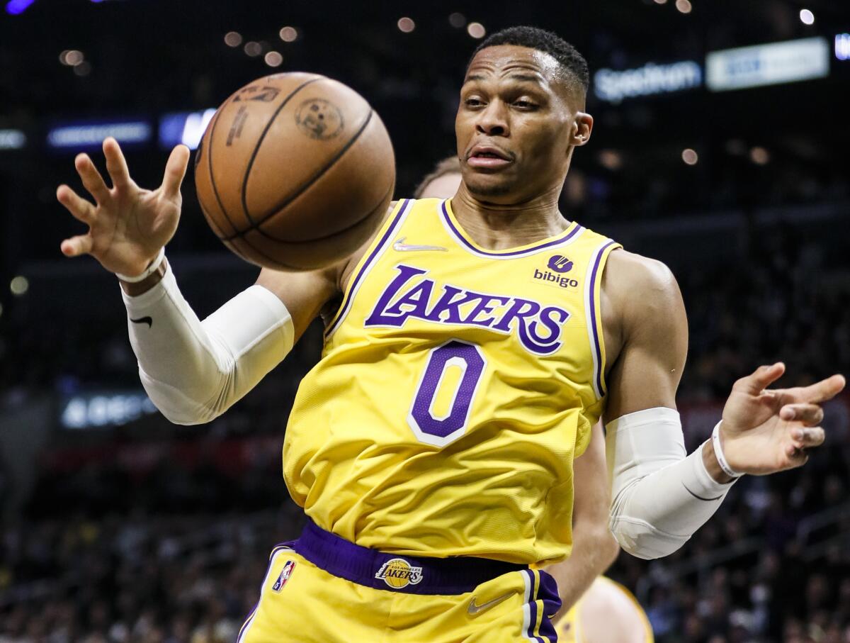 Lakers guard Russell Westbrook reaches for the loose ball.