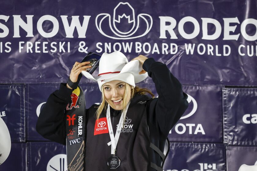 Eileen Gu of China celebrates on the podium after her victory in the women's World Cup freestyle ski halfpipe event in Calgary, Alberta, Saturday, Jan. 21, 2023. (Jeff McIntosh/The Canadian Press via AP)