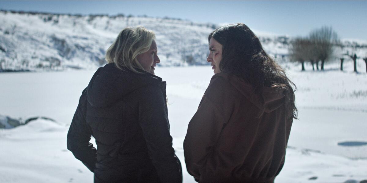 Two women standing face to face in a snowy field.