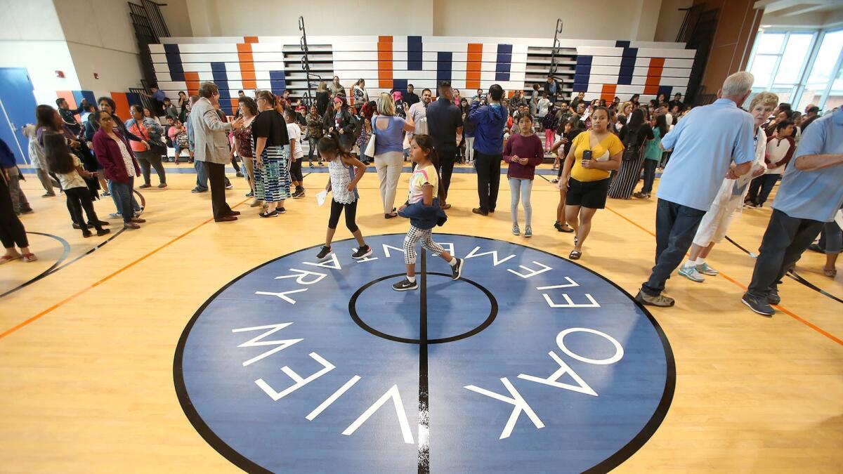 The center logo at the Oak View Elementary School gym and multipurpose room is unveiled during Monday's grand opening in Huntington Beach.