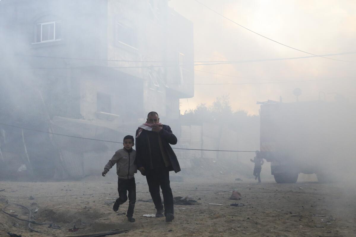 Palestinians run away after an Israeli strike on a residential building on Monday in Rafah, Gaza Strip.