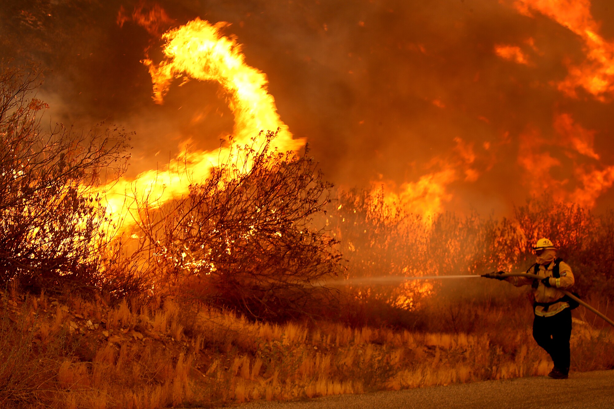 A firefighter battles the Fairview fire along Batista Road
