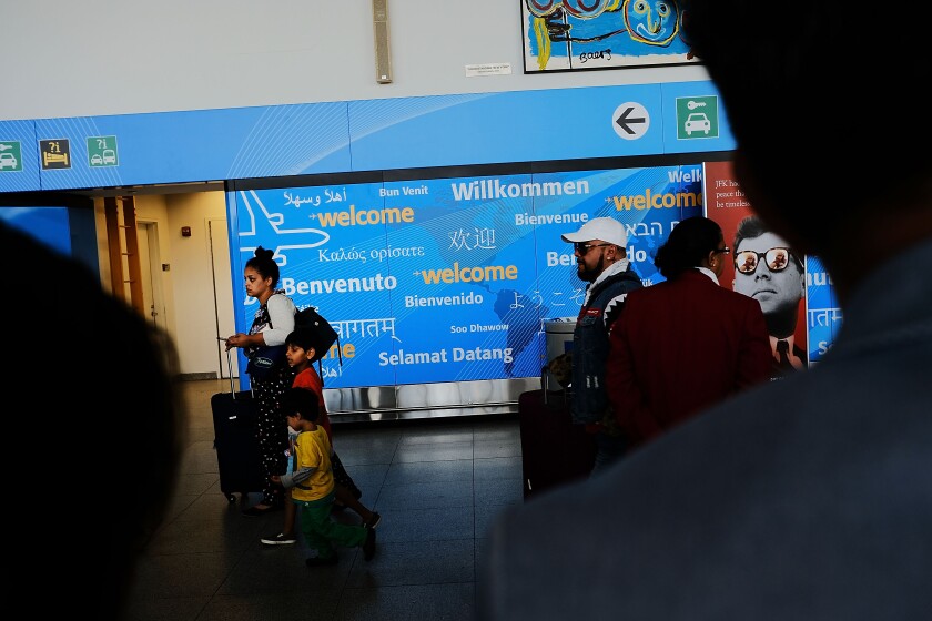 People walk through international arrivals at terminal four at John F. Kennedy (JFK) airport.