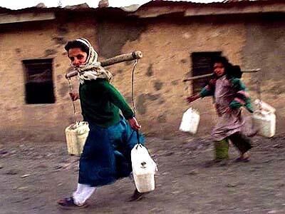 Girls carry water back to their home in Jabal-os-Saraj in northern Afghanistan. The children of Jabal-os-Saraj are used to war.