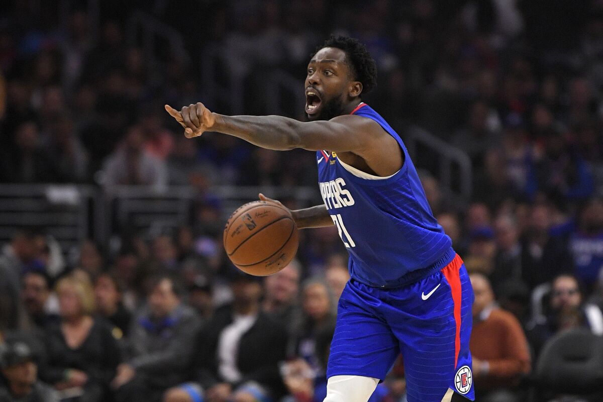 Clippers guard Patrick Beverley gestures while dribbling during a game.