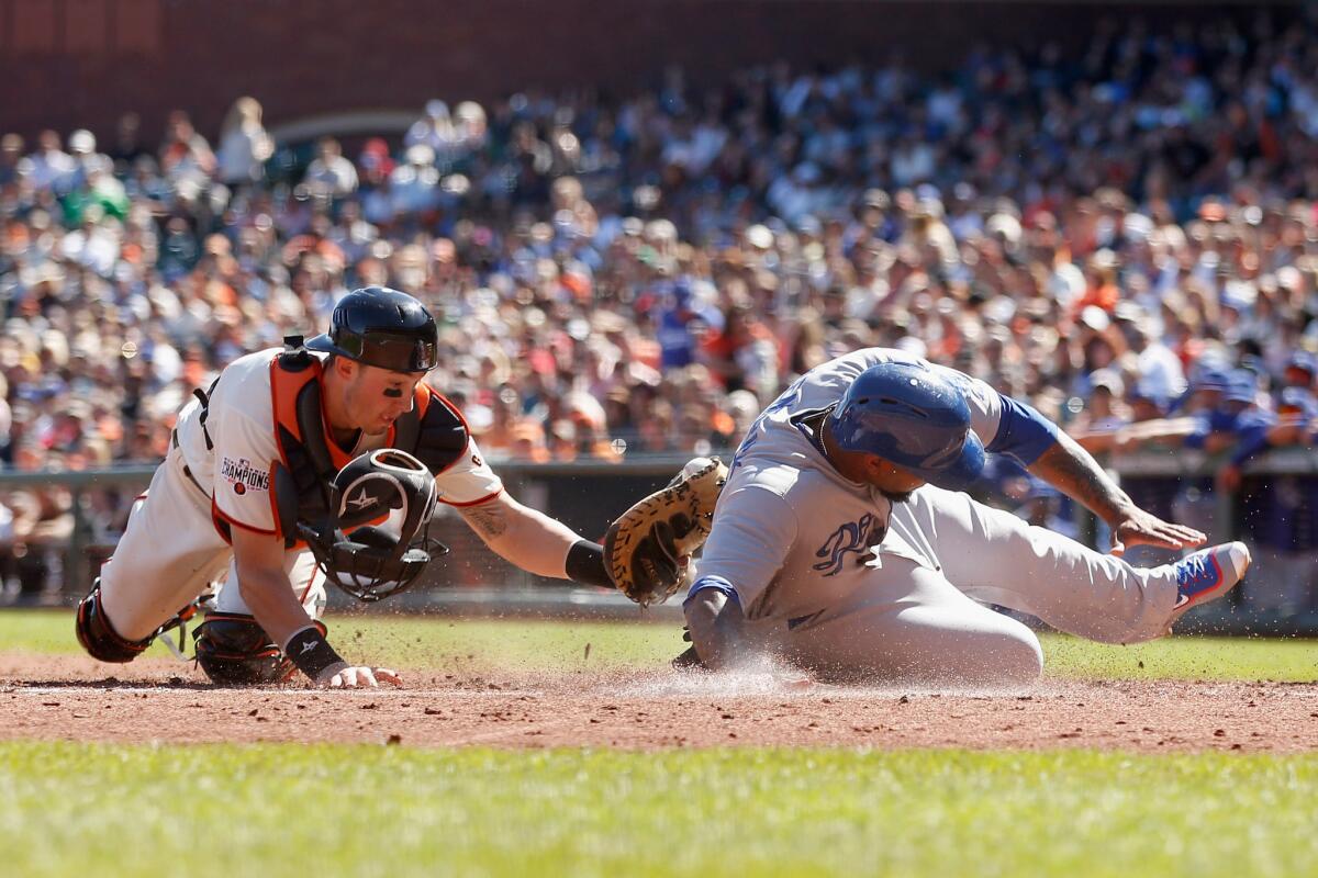 Dodgers second baseman Howie Kendrick slides safely past the tag of Giants catcher Trevor Brown to score on fielder's choice by teammate Andre Ethier in the third inning Thursday at AT&T Park.