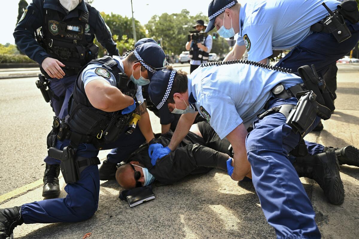 A man is pinned on the ground by law enforcement officers