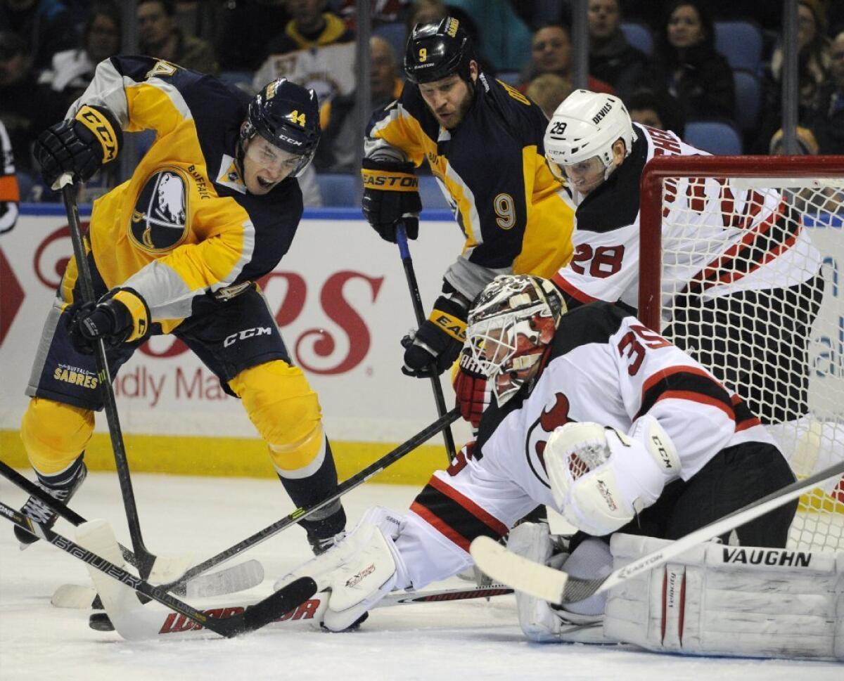 Buffalo's Brayden McNabb, left, tries to put the puck past New Jersey goalie Cory Schneider earlier this season.