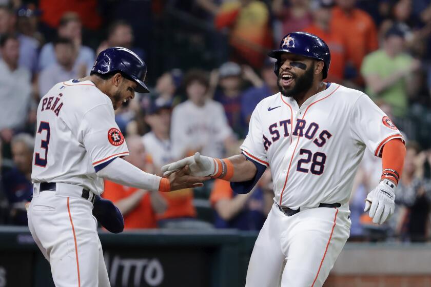 Houston Astros' Jeremy Pena (3) and Jon Singleton (28) celebrate after the both score on a two-run home run by Singleton against the Los Angeles Angels during the sixth inning of a baseball game Tuesday, May 21, 2024, in Houston. (AP Photo/Michael Wyke)