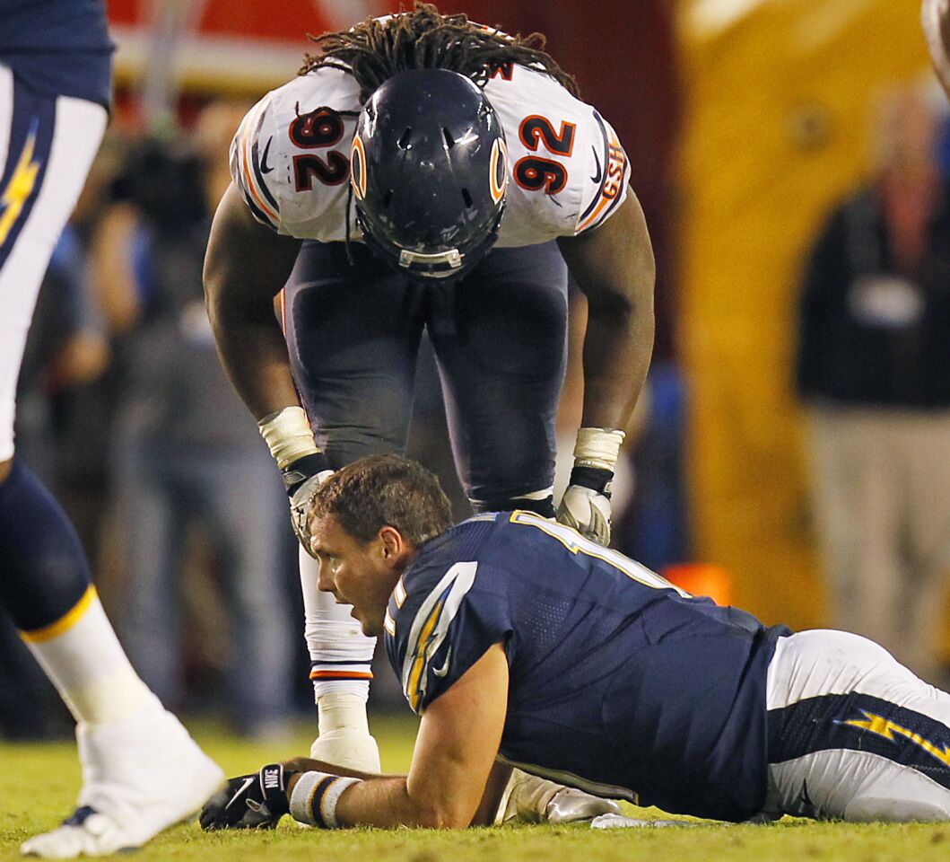 Chargers Philip Rivers lays on the ground after getting hit on a 4th down play on their final drive as Bears Pernell McPhee looks down on him during a Monday Night Football game on Nov. 9, 2015.
