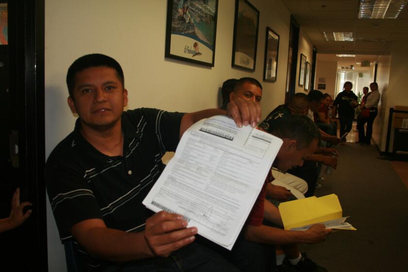 El salvadoreño Mario Mejía muestra el formulario del TPS durante una jornada de reinscripción a este alivio migratorio.