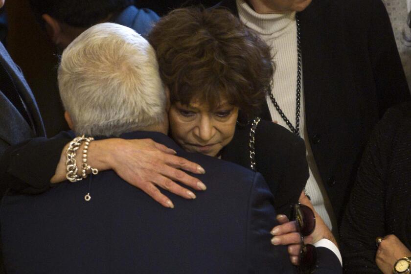 ARCHIVO - Cristina Pacheco, viuda del escritor y poeta mexicano José Emilio Pacheco, recibe un abrazo en el homenaje fúnebre a su marido en Ciudad de México, el 27 de enero de 2014. Pacheco, una de las principales cronistas de los últimos 50 aos de la historia de la capital mexicana, murió el jueves 21 de diciembre de 2023 a los 82 aos. (AP Foto/Christian Palma, Archivo)