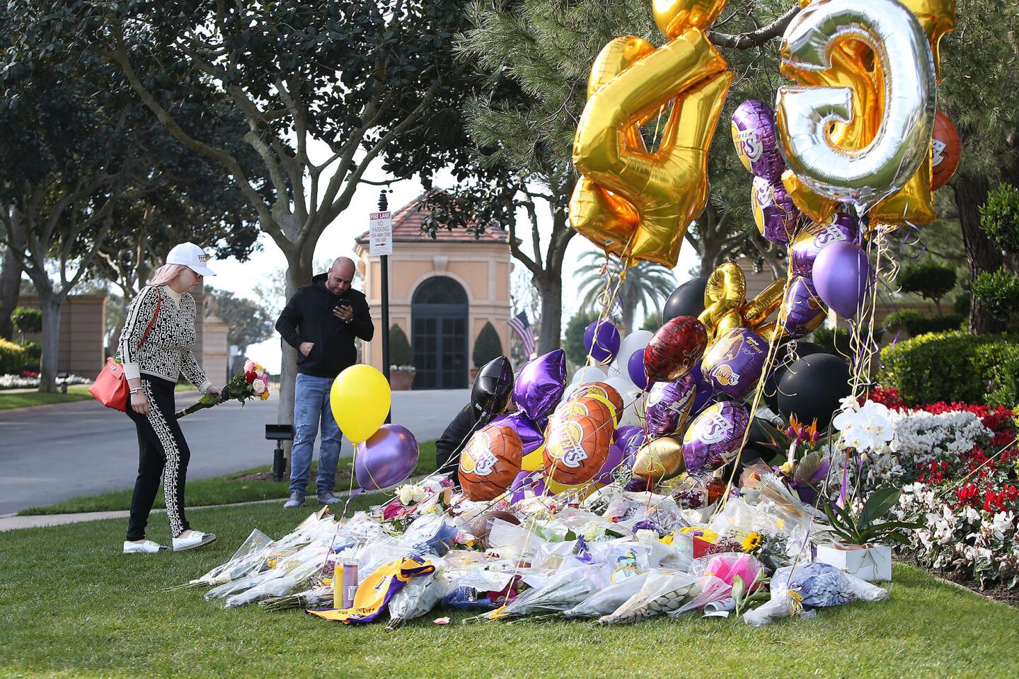 People pay tribute to Kobe Bryant outside the gated community in Newport Coast where his family lives.