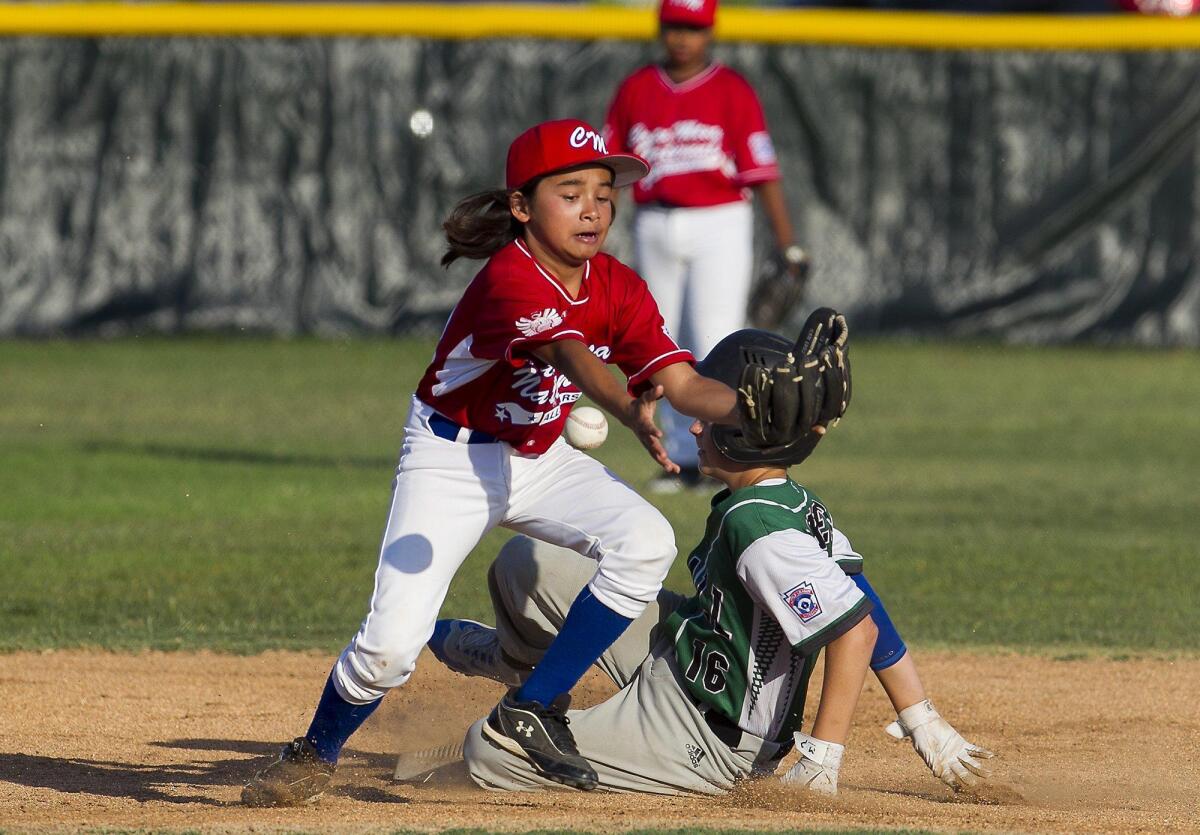 Costa Mesa National's Jonah Shapiro, left, tries to collect the ball as Costa Mesa American's Nate Baker slides safely into second base in the opening round of District 62 Little League baseball all-star tournament at Mile Square Park.