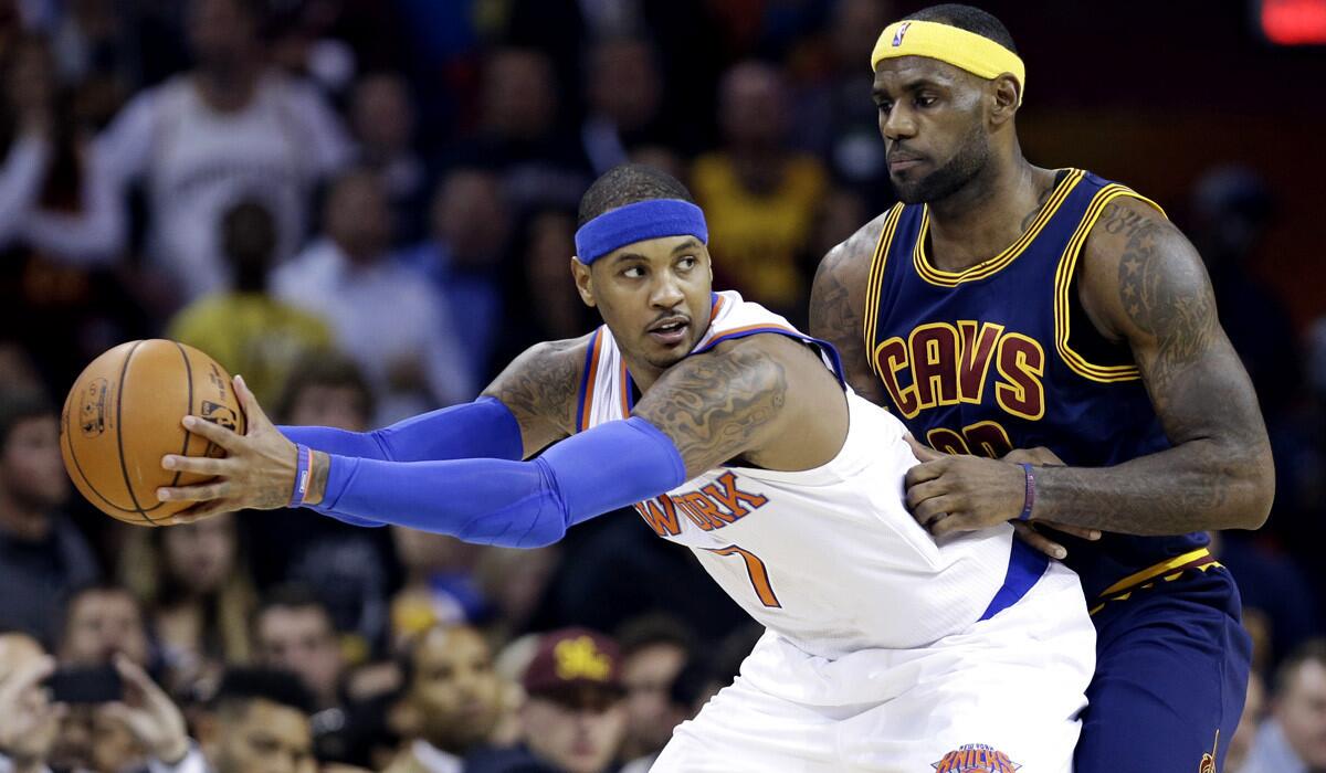 Knicks forward Carmelo Anthony protects the ball from Cavaliers forward LeBron James while working in the post during their game Thursday night in Cleveland.