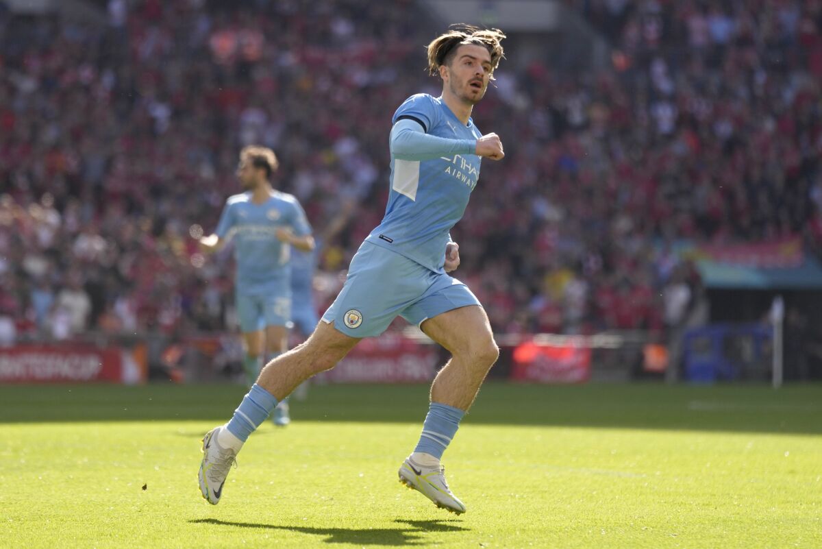 Manchester City's Jack Grealish celebrates after scoring his side's first goal during the English FA Cup semifinal soccer match between Manchester City and Liverpool at Wembley stadium in London, Saturday, April 16, 2022. (AP Photo/Kirsty Wigglesworth)
