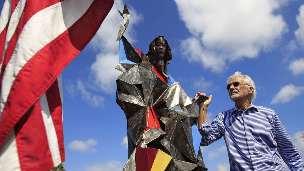 Artist Jim Bliesner stands next to a model of his statue of the Mary as Lady Liberty. Named "Welcome the Stranger", the 40-foot-tall statue at Our Lady of Mt. Carmel Church will overlook the U.S.-Mexico border.