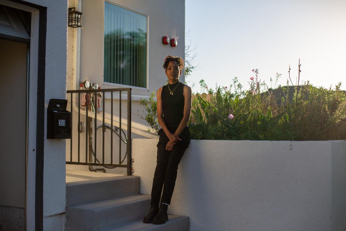 Kyshawna Johnson stands outside a home.
