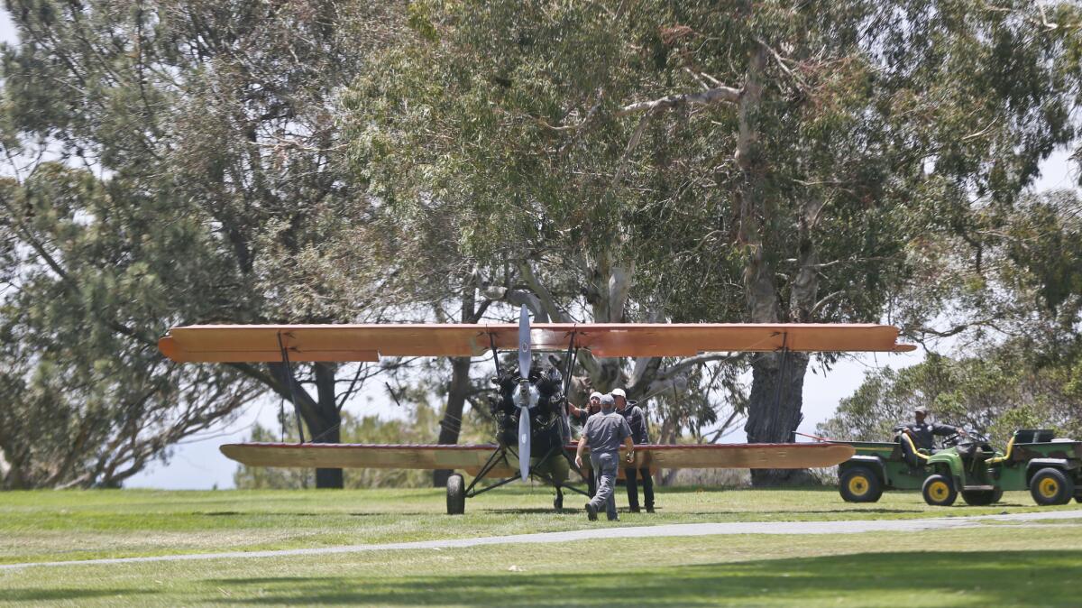 Members of the ground crew at Torrey Pines golf course inspect an airplane that made an emergency landing on the North Course at Torrey Pines on Tuesday.