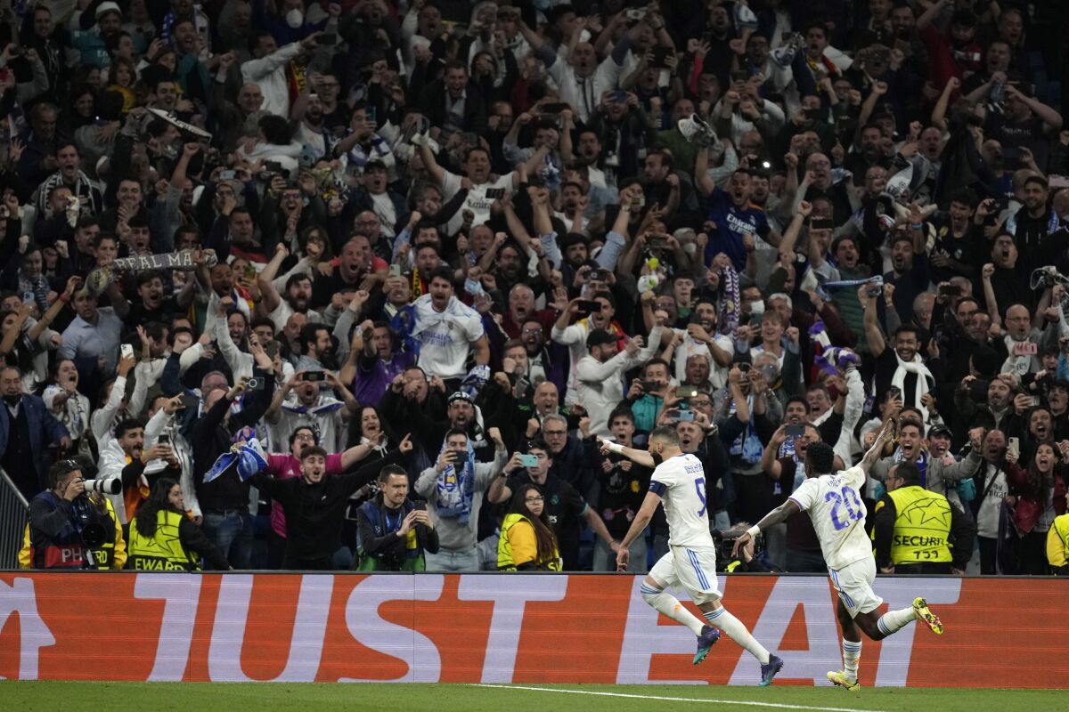 Real Madrid's Karim Benzema, left, celebrates his side's third goal during the Champions League semi final, second leg, soccer match between Real Madrid and Manchester City at the Santiago Bernabeu stadium in Madrid, Spain, Wednesday, May 4, 2022. (AP Photo/Bernat Armangue)
