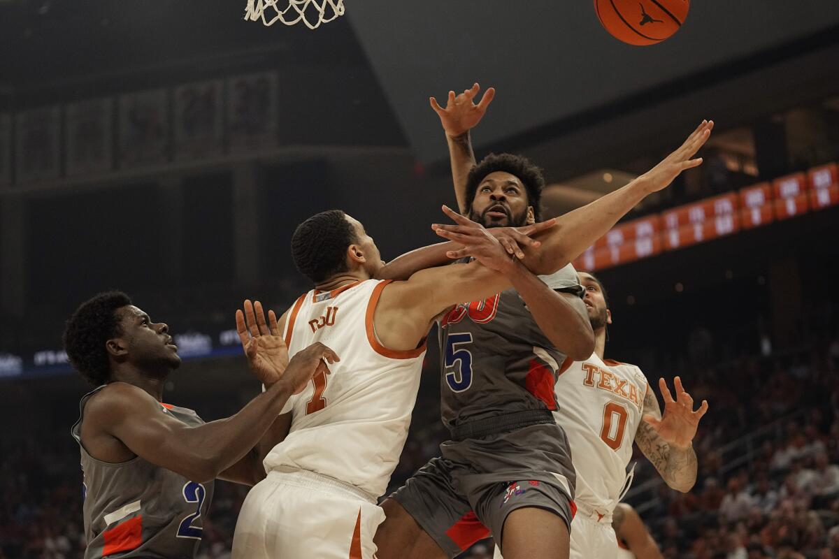 Houston Christian forward Jason Thompson (5) is blocked by Texas forward Dylan Disu (1) as he tries to score during the first half of an NCAA college basketball game, Thursday, Nov. 10, 2022, in Austin, Texas. (AP Photo/Eric Gay)