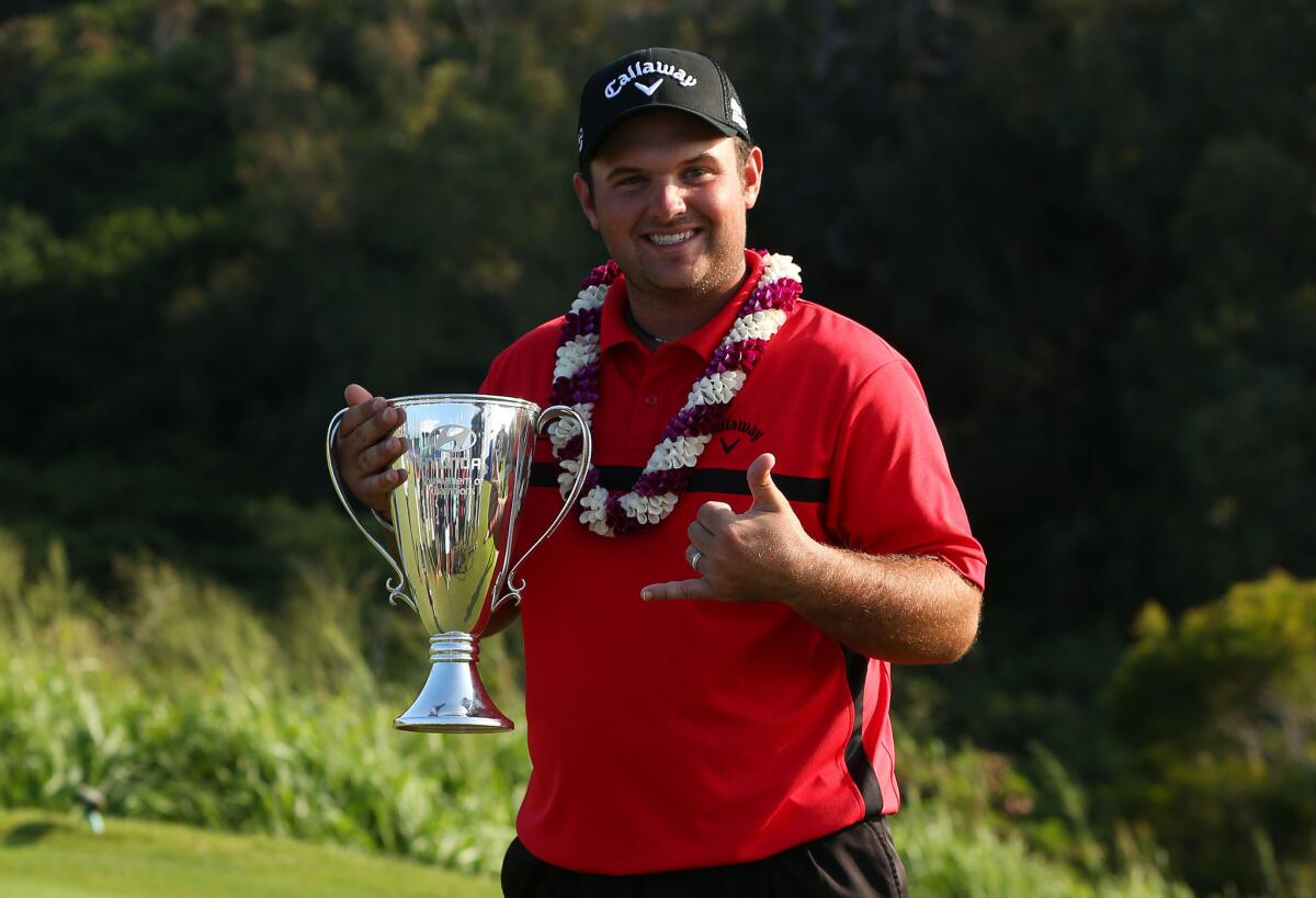 Patrick Reed poses with the winner's trophy after his come-from-behind win in the Hyundai Tournament of Champions in Kapalua, Hawaii.