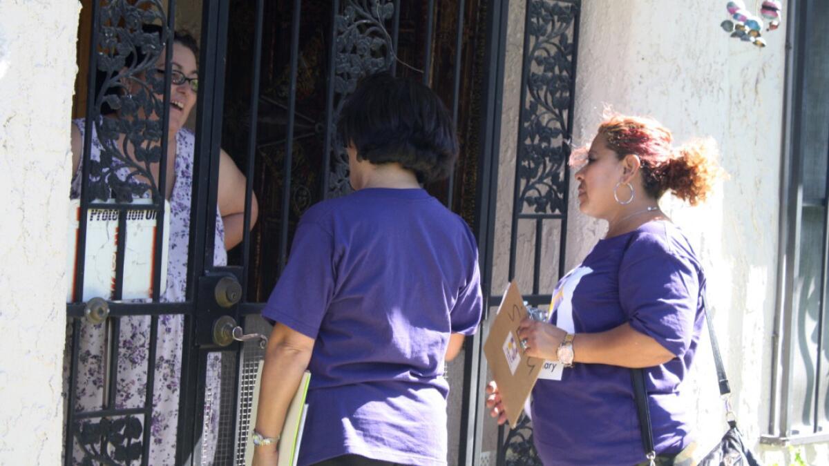 SEIU Executive Vice President Rocio Sáenz and janitor Dora Diaz of Los Angeles speak with Claire Voss, 47, of Las Vegas at her home.